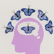 Creative coaching with art therapy concept showing blue butterflies emerging from a paper-cut human mind, symbolizing emotional expression and personal transformation.